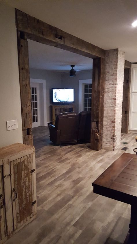 Take a look at these reclaimed wood beams used to frame the walkway between the kitchen and living room in this home. What a unique touch! Cedar Beams Living Room, Archway Between Kitchen And Living Room, Beam Between Kitchen And Living Room, Maine Kitchen, Archways In Homes, Modern Cabin Interior, Beams Living Room, Reclaimed Beams, Brick Columns