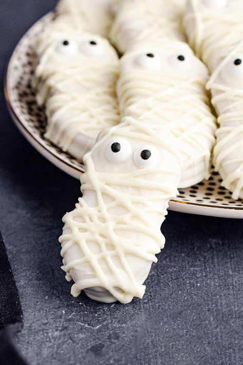 Nutter Butter Mummies! These peanut-butter-infused Nutter Butter mummies are a cute and spooky dessert to whip up for any Halloween party or event. Plus, you only need 3 ingredients! | HomemadeHooplah.com Halloween Mummy Cookies, Halloween Craft Night, Easy Halloween Cookies Recipes, Pumpkin Spice Latte Cupcakes, Halloween Candy Bark, Mummy Cookies, Halloween Cookie Recipes, Wilton Candy Melts, Spooky Halloween Treats