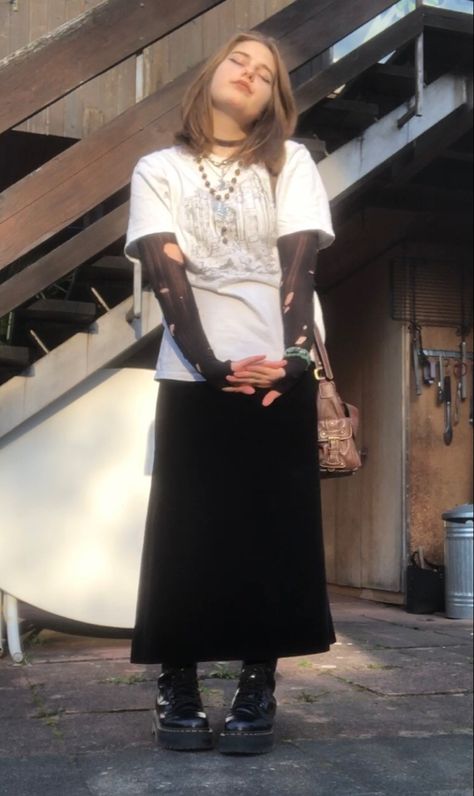 A mid-size person/girl wearing a black thrifted ripped stockings longsleeve, a white wide graphic shirt over it, a wide dark black velvet maxi skirt, black platform dr. Martens and multiple crystal rings and bracelets. 	The person is also wearing multiple silver necklaces, one in form of a moon and another in form of a fairy  necklace, a brown rosary-style fairy bead necklace, a vintage necklace and a black lace choker. Velvet Black Skirt Outfits, Black Velvet Maxi Skirt, Maxi Skirt Oversized Shirt, Long Black Velvet Skirt Outfit, Goth Maxi Skirt Outfit, Velvet Maxi Skirt Outfit, Brown Maxi Skirt Outfit, Goblincore Goth, Fit Aesthetic Outfit