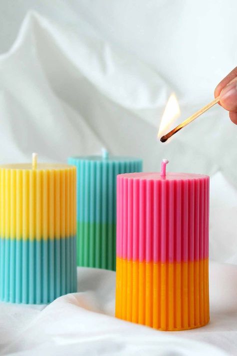 Image of three ribbed pillar candles of different colours with a hand lighting one of them with a match. Coloured Pillar Candles, Bathroom Candles Decor, Pillar Candle Centerpieces, Turquoise Candles, Handmade Candles Diy, Living Room Shelf, Picked Flowers, Soya Mumu, Room Shelf