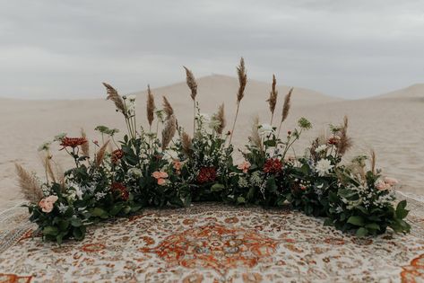 Mums And Pampas, Pampas Grass Ground Arch, Grounded Floral Arches Wedding, Wildflower Floral Arrangements, Ground Floral Arrangements Wedding, Bleached Italian Ruscus, Dunes Photoshoot, Sand Dunes Photoshoot, Alter Flowers