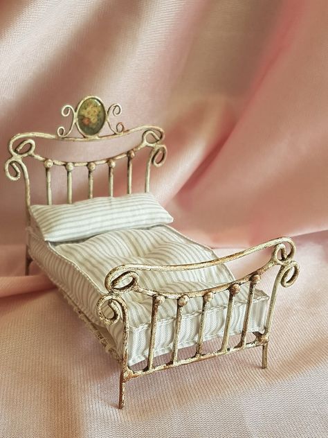 Miniature iron bed for dollhouse, 1/24 scale. A piece manufactured by me, completely handmade. It has a nice medallion on the headboard and an old blank finish. The bed is accompanied by a pillow and a nice and fluffy mattress. The mattress fabric, according to stock in the workshop at that time. I do not work in series, everything is manufactured by me, with many hours of work and dedication. The work is done in particular for the person making the assignment. I regret the waiting times, but I Miniature Iron, Miniature Bed, Cinderella Moments, Dollhouse Bed, Dollhouse Bedroom, Antique Dollhouse, Doll House Crafts, Dollhouse Projects, Dolls House Interiors