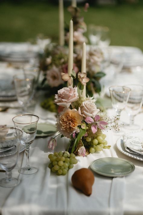 Incorporating fruit into the tablescapes added a timeless sophistication to the design. The vendors made sure to choose fruit that would naturally grow in the European destinations they were using as inspiration. Flowers And Fruit Centerpieces, Fruit Floral Centerpieces, Grape Wedding Decor, Grape Table Decor, Wedding Centerpieces With Fruit, Wedding Fruit Decor, Fruit Table Ideas Wedding, Summer Wedding Tablescapes, Fruit Wedding Decor