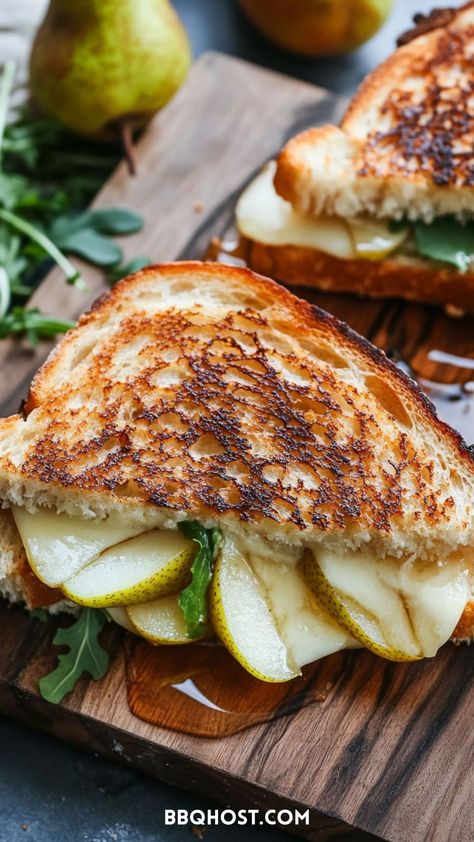 Experience the exquisite flavors of this Brie and Pear Grilled Cheese! Crisp, juicy pear slices combined with creamy brie create a melt-in-your-mouth sensation that’s upgraded by a drizzle of sweet honey and a handful of peppery arugula. This delightful sandwich is not just one of the best grilled cheese sandwiches; it’s an epic upgrade that will leave you craving more. Save this now and check out the blog for more recipes! Honey Goat Cheese Grilled Cheese, Brie Arugula Sandwich, Pear Grilled Cheese, Goat Cheese Grilled Cheese, Fontina Grilled Cheese, Brie And Pear, Arugula Sandwich, Quick And Easy Comfort Food, Honey Goat Cheese