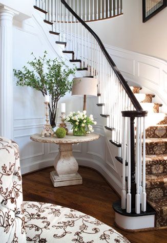 In the entry, a concrete table echoes the curved lines of the stairwell. Renovating Stairs, Round Foyer, Entry Staircase, Foyer Table Decor, Round Entry Table, Round Stairs, Entryway Stairs, Foyer Furniture, Small Staircase