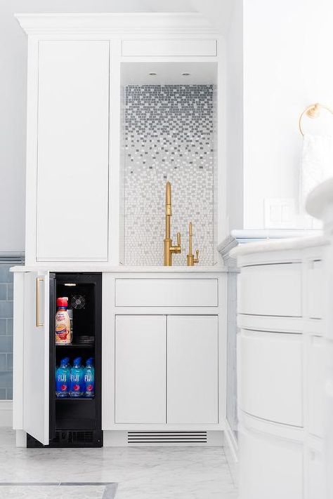 Elegant bathroom coffee station boasts a mini refrigerator concealed behind a white door with a brass pull and positioned beside white flat front cabinets. Hidden Bath, Flat Front Cabinets, Fridge Design, Room Door, Bath Room, Elegant Bathroom, Trendy Kitchen, Mini Fridge, Painting Bathroom