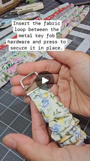 2K reactions · 540 shares | Let's make scrunchie keyfob

1) Cut your fabric into a rectangle measuring approximately 3 x 22 inches.

2) Fold the fabric in half lengthwise with the right sides facing each other.

3) Sew along the long edge of the fabric.

4) Turn the fabric tube right side out so that the seam is on the inside. Use a turning tool or a safety pin to help if needed.

5) Cut elastic at 8.5 inches. I'm using 3/4 non-roll knit elastic.

6) Attach a safety pin to one end of the elastic and feed it through the fabric tube.

7) Sew both ends of the elastic together securely.

8) Place the raw edges of the fabric loop between the metal key fob hardware. Make sure the fabric loop is centered within the hardware. Use pliers to press the hardware closed, securing the fabric loop in pla Scrunchie Key Fob, Key Crafts, Quilt Sewing Patterns, Turning Tools, A Rectangle, Craft Show Ideas, Key Fobs, Safety Pin, Pliers