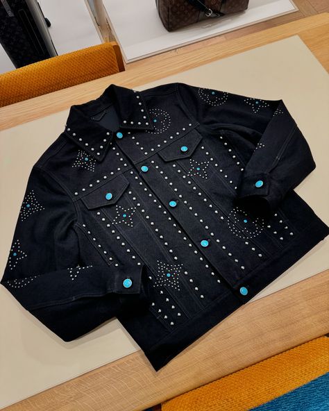 This embellished black denim jacket channels the dandy Western themes of the FW24 Show, with a Monogram Flower pattern picked out with metal studs to create a graphic effect, and an LV signature within a radiant sun motif on the back. Turquoise buttons and decorative rivets further ornament this meticulously crafted piece, which brings a sophisticated twist to casual looks. #leaguefits #louisvuitton #louisvuittonbags #louisvuittonbag #louisvuittonaddict #louisvuittonlover #lvcommunity #lvwor... Lv Clothes, Monogram Jacket, Creative T Shirt Design, Louis Vuitton Men, Black Denim Jacket, Ny Fashion, Luxury Outfits, Black Denim, Insta Fashion