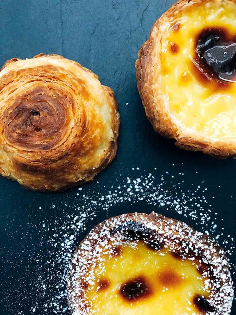 This pastéis de nata recipe makes as-close-to-authentic Portuguese custard tarts with a rich egg custard nestled in shatteringly crisp pastry. Tastes like home, even if you're not from Portugal. #pasteis #pastel #pasteisdenata Nata Recipe, Natas Recipe, Poulet General Tao, Portuguese Custard Tarts, Portuguese Tarts, Portuguese Egg Tart, Custard Tarts, Puff Pastry Crust, Portuguese Desserts