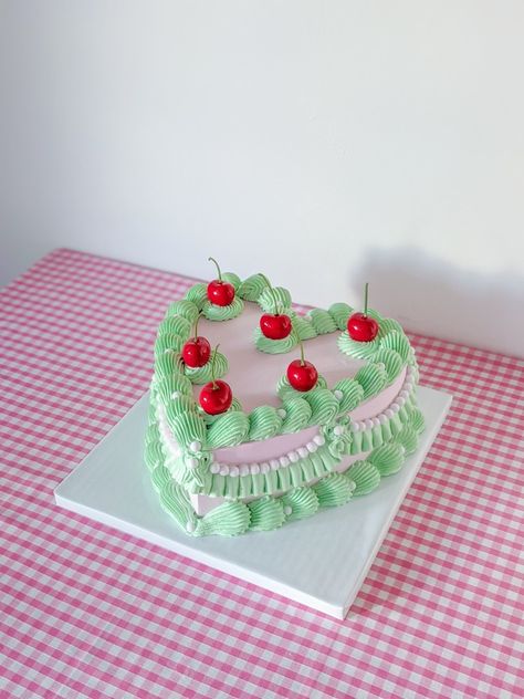 Fake cake in pastel green and pale pink decorated with cherries and candy pearls Green Heart Birthday Cake, Pink Green Cake, Green Heart Shaped Birthday Cake, Pink And Green Cake, Pink And Green Cakes, Cherry Decorated Cake, Fake Cake Ideas, Green And Pink Heart Cake, Pink Heart Cake With Cherries