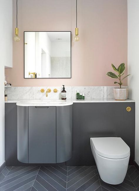 A dark gray curved bath vanity topped with quartz countertops against a pink bathroom wall lit by black and gold hanging Edison bulb lights. Bathroom Colors Blue, Pink Bathroom Tiles, Pink Bedroom Walls, Industrial Style Bathroom, Grey Countertops, Bathroom Modern, Bathroom Backsplash, Pink Bathroom, Grey Bathrooms