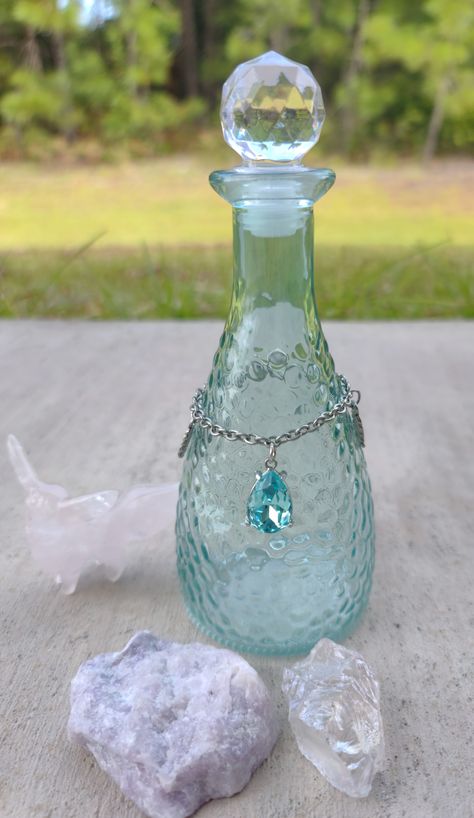 A glass jar with a removable top. Decorative charm adornment is removable. Jar measures 7 inches tall by 3 inches wide. This jar can be used for moon water, sun water, storm water, hurricane water, potions, storing spell ingredients, herbs, or anything you like!

The crystal jar has gorgeous blue crystal charm with two metal leaf charms! It has turquoise glass. Moon Water Jar, Moon Witchcraft, Spell Ingredients, Witchcraft Tips, Crystal Jar, Water Jar, Storm Water, Moon Water, Sun Water