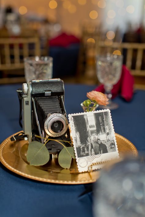 Camera centerpiece. Travel theme wedding decor. Navy, wine, blush, and gold. Vintage Camera Wedding Decor, Travel Theme Wedding Centerpieces Table Settings, Vintage Camera Centerpiece, Camera Centerpieces, Camera Centerpiece Ideas, Travel Themed Table Decorations, Travel Themed Centerpieces Diy, 40s Themed Wedding, 1940s Wedding Decor