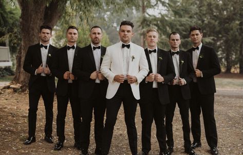 Cream White Tuxedo Wedding, Black Tux With Champagne Vest, Black And White Tuxedo Wedding Groomsmen, Groomsmen Attire White And Black, Black Tux Wedding Cummerbund, White Tux Black Shirt, White Groom Black Groomsmen, Cream Jacket Black Pants Groom, Tan Jacket Black Pants Wedding