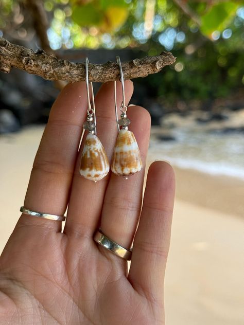 "Mexico X Kauai" Collection ✨ * Genuine & rare, handpicked cone shells off the coast of Bahia de Banderas Mexico * Your choice of 5 different cone shell style earrings in 14k gold fill. Please see drop down menu and refer to abbreviations for your choice of style. If you have any questions, please feel free to message me. Labradorite stone SS - Sterling silver Marquis ear wires with labradorite stones & cone shells (Approx. 2" in length)  14k GF beaded chain - 14k gold fill Marquis ear wires with pink Keshi pearls and cone shells (Approx. 2" in length) Moonstone tear drop - Moon stone tear drops suspended from cone shells (Approx. 2.25" in length)  Huggie hoops - 14k gold fill beaded chain with beautiful dangling cone shells (Approx.  3" in length)  Marquis pink pearl - Medium huggie hoops Ears Ringing, Photograph Jewelry, Seashell Jewelry Diy, Cone Shell, Sea Jewelry, Tear Drops, Seashell Jewelry, Keshi Pearls, Shell Jewelry