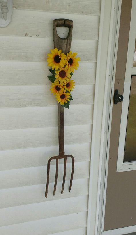 Rustic pitchfork with sunflowers for our front porch. Sunflowers On Front Porch, Pitchfork Decor Ideas, Sunflower Yard Decor, Sunflower Stake Ideas, Sunflower Door Painting, Patio Crafts, Sunflower Barn Doors, Old Door Decor, Western Games