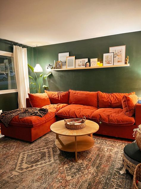 Maximalist Design and Decor | struggling on what to put in these picture frames Moody Living Room Orange Couch, Green Couch Orange Pillows, Burnt Orange Western Living Room, Burnt Orange Grey Living Room, Green Burnt Orange Living Room, Rust Color Living Room, Dark Orange Living Room, Burnt Orange Sofa Living Room Ideas, Rust Couch Living Room