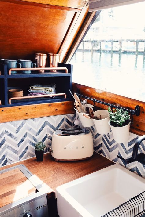 This tiny houseboat is full of chic storage solutions and organization techniques that apply to any small space - not just boats. We love how organized the kitchen area is. Boat Makeover Interior, Boat Interior Ideas Cabins, Tiny House Kitchens, Houseboat Interiors, Chevron Tile Backsplash, Small Houseboats, Houseboat Ideas, Boat Cabin, Sailing Life