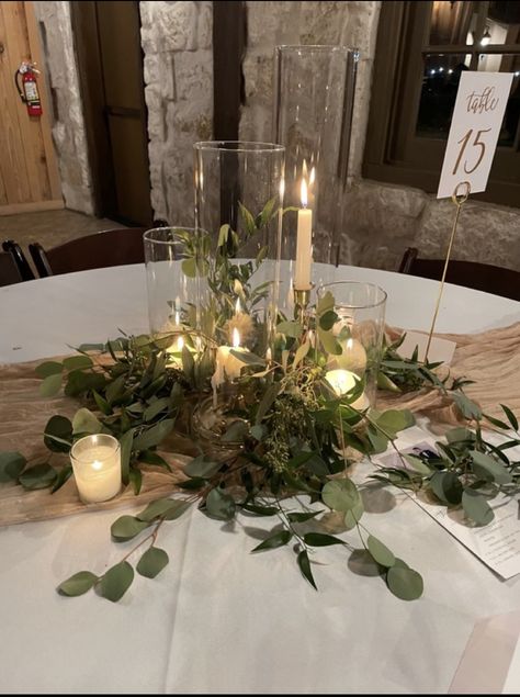 Candle And Glass Centerpieces, Dark Green Wedding Details, Greenery Wedding Circle Table, Eucalyptus Wedding Circle Table, Eucalyptus And Gold Wedding Table Decor, Wedding Table Flowers With Candles, Wedding Tablescapes Round Rustic, Greenery On Black Tablecloth, Dark Green And Gold Centerpieces