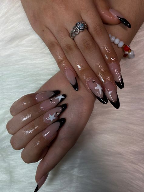 black french tip almond nails with white stars on middle and ring finger Black French Star Nails, Long Almond Acrylic Nails Designs, Almond Star Nails, Almond Y2k Nails, Nail Ideas For Black Dress, Star Almond Nails, Extra Nails Designs, Cute Basic Nails, Pointy Almond Nails