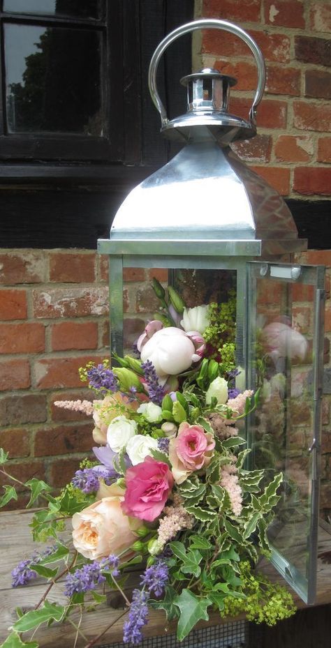 Lantern with cascading flowers including pale pink peony, vuvuzela roses, peach lisianthus, cream spray roses, lavender, ivy and achillea mollis - Bury Court Barn Lantern With Flowers, Pale Pink Peonies, Cascading Flowers, Lantern Ideas, Lantern Centerpieces, Flower Arrangements Diy, Floral Arrangements Wedding, Beautiful Flower Arrangements, Pink Peony