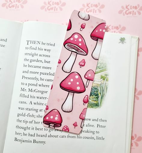 This handmade pink mushroom laminated bookmark is perfect for adding a touch of whimsy to your reading routine.  Unique Design: The pink mushroom design is eye-catching and adds a pop of colour to your books.  Handmade: Each bookmark is handmade.  Durable Material: The glossy lamination ensures that the bookmark will last for multiple reads without tearing or bending.  Width: 2 Inches Height: 6 Inches Mushroom Bookmark, Reading Routine, Pink Mushroom, Benjamin Bunny, Plant Journal, Birthday Card Craft, Mushroom Design, Beaded Jewelry Designs, Avid Reader