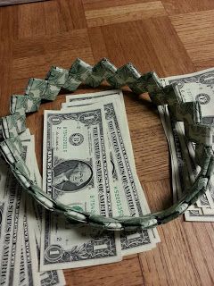 Money Headband for Graduation.   I remember making bracelets like this (with gum wrappers) when I was a kid. Money Headband, Lei Making, Graduation Money Gifts, Folding Money, Dollar Origami, Dollar Bill Origami, Graduation Money, Graduation Leis