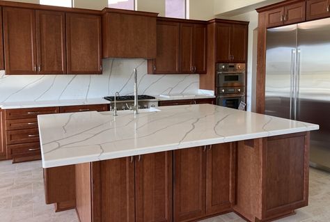 Gorgeous cherry cabinet kitchen showing Wellborn Cabinets in Millbrook door style. The polished quartz Calacatta Laza Gold countertops have just the right amount of veining to add contrast and character against the cherry cabinetry. For more #kitchenremodel inspiration visit www.twdaz.com today! #remodel #kitchendesign #cherrycabinets #twdaz How To Make Cherry Cabinets Look Modern, Floors For Cherry Cabinets, English Chestnut Kitchen Cabinets, Flooring For Cherry Cabinets, Cherry Cabinets With Quartz Countertops, Dark Maple Kitchen Cabinets With White Quartz, Cherry Cabinets Gold Hardware, Kitchen Ideas Cherry Wood Cabinets, Quartz With Cherry Cabinets