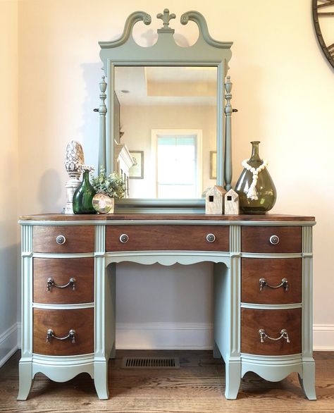 This beautiful vanity was stripped down to her bare wood to free her of all the dirt and grime and imperfections. Once prepped, the drawers and top were stained with Early American by Minwax and sealed with a Minwax Satin finish polyurethane. The body and mirror of this piece have three coats of General Finish’s milk paint in Basil. All original hardware was replaced due to being damaged or missing. This piece had been given up on but I saw she still had life. Vintage Vanity Refurbished Diy, Refurbished Vanity Dresser, Two Tone Desk Color Ideas, Antique Vanity In Bathroom, Refinished Vanity Antique, Refurbished Vanity Ideas, Two Tone Dressers, Vanity Paint Ideas, Restored Vanity