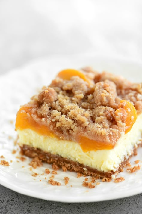 Peach Cobbler Cheesecake Bars, Peach Cobbler Cheesecake Cups, Peach Cheesecake Bars, No Bake Peach Cheesecake, Caramel Syrup Recipe, Cobbler With Bisquick, Peach Cobbler Cheesecake Recipe, Peaches Recipes, Peach Cobbler Cheesecake