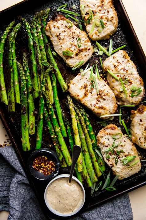 Baked Boneless Pork Chop and Asparagus Sheet Pan Dinner  by The Modern Proper. One pan. 30 minutes. Irresistibly delicious and healthy, this tender baked pork chop and asparagus sheet pan dinner gets a major flavor boost from a simple, genius garlicky mayo-mustard sauce. Modern Proper Sheet Pan, Pork Chop Asparagus Recipes, Pork Asparagus Recipes, Sheet Pan Pork Chops And Asparagus, Pork Chops With Asparagus, Pork Chops And Asparagus In Oven, Pork Chop And Asparagus Recipes, Pork And Asparagus Recipes, Pork Chops And Asparagus