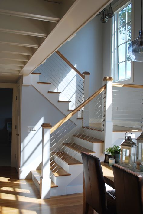 Coastal Home | Coastal Staircase | Cable Wire Staircase | Seaside Home | Custom Home Design Beach House Staircase Ideas, Coastal Stair Railing, Stair Railing Ideas Coastal, Beach House Stairs Staircases, Lake House Staircase, Interior Cable Stair Railing, Beachy Staircase, Beach Staircase, Modern Coastal Staircase