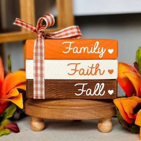 NEW BOOK STACK SIZE AVAILABLE!  This cute fall wooden book stack bundle is the perfect addition to your fall tiered tray decorations. It will bring the cozy fall feel to your home and look perfect wherever you decide to put it. Whether it be on a tiered tray, fall farmhouse mantle, bookshelf or as part of an autumn decorative centerpiece. All of our mini book stacks and larger size bookstacks are handmade & hand painted. ❤PLEASE READ DESCRIPTION, PROCESSING TIMES & ESTIMATED SHIPPING DATES IN ITS ENTIRETY.❤ ❤ SIZE: WE ARE NOT RESPONSIBLE FOR FAILURE TO READ DIMENSIONS OR PROCESSING TIMES ORIGINAL MINI BOOK STACK SIZE: 2.25" tall 3.5" wide 2.25" deep NEW LARGER BOOK STACK SIZE: 2.25" tall 5" wide 3.25" deep PLEASE REFER TO OUR SHOP BANNER PHOTO THAT SHOWS HOW THE SIZE DIFFERS. RIBBON, WORDI Wooden Book Decor, Mantle Bookshelf, Stack Books, Farmhouse Mantle, Wood Books, Fall Tray, Fall Tiered Tray Decor, Faux Books, Craft Booth Displays