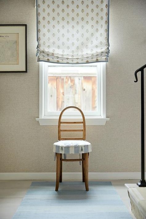 A vintage ladder back chair accented with a skirted seat cushion sits on a blue runner beneath a window covered in a white and blue block print roman shade and framed by gray grasslcoth wallpaper. Grey Grasscloth Wallpaper, Sarah Bartholomew, Blue Block Print, French Headboard, Glass Pocket Doors, Wooden Cribs, White Wainscoting, Vintage Ladder, Oak Nightstand