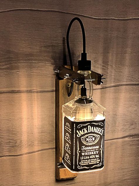 Price: $95.00USD     This lamp is made entirely by hand from authentic old oak barrels of 1966 and a bottle of whiskey "JACK DANIELS" with both arms and fly nuts you can adjust the position that is best for you. The design is maintained in an old industrial style. Every element has #Bottlelamp #Industrial #Kitchendesign #Led #Lightingdesign #Oak #Sconce #Vintagelighting Whiskey Bottle Crafts, Whiskey Bottle Lamp, Whisky Jack Daniels, Liquor Bottle Lamp, Bottle Projects, Jack Daniels Bottle, Liquor Bottle Crafts, Lamp Kitchen, Vintage Compass