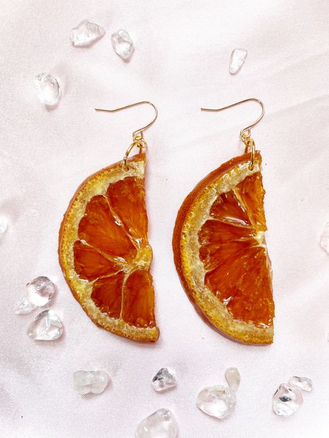 Shiny half of an orange slice. It has been dried and made into earrings. Gold ear wires. Fruit Resin, Orange Trees, Yellow Wildflowers, Orange Slice, Dried Oranges, Artist Custom, Iridescent Green, Crystal Resin, Unique Collectibles