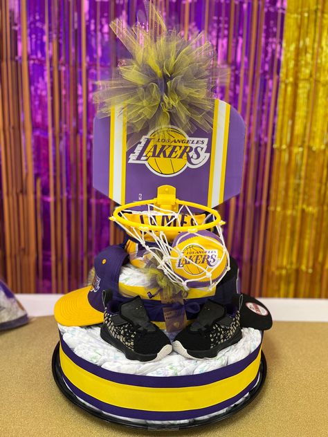 3-tier diaper cake made with Lakers basketball hoop, infant hats, onesies, and Lebron infant shoes Infant Hats, Basketball Ideas, Lakers Basketball, Infant Shoes, Baby Diaper Cake, Basketball Hoop, Baby Diaper, Baby Shower Theme, How To Make Cake