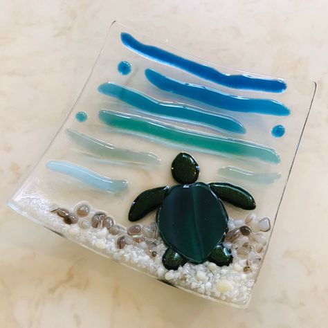 Fused Glass Sea Turtle Plate with a beautiful sparkly Green Sea Turtle resting on the beach :) French Vanilla for the sand, Brown and White for the rocks by the water, calming Turquoise, Blue, and Aquamarine ocean waves and bubbles.  This dish is Contour fused for a beautiful texture. Each piece retains its individual character, while edges are soft and rounded. If it is used as a soap dish, the raised glass pieces would help the soap dry out.  Please note that all my items are Handmade so there Glass Sea Turtle, Fused Glass Dishes, Fused Glass Wall Art, Fused Glass Plates, Glass Fusion Ideas, Fused Glass Artwork, Glass Fusing Projects, Fused Glass Ornaments, Glass Centerpieces