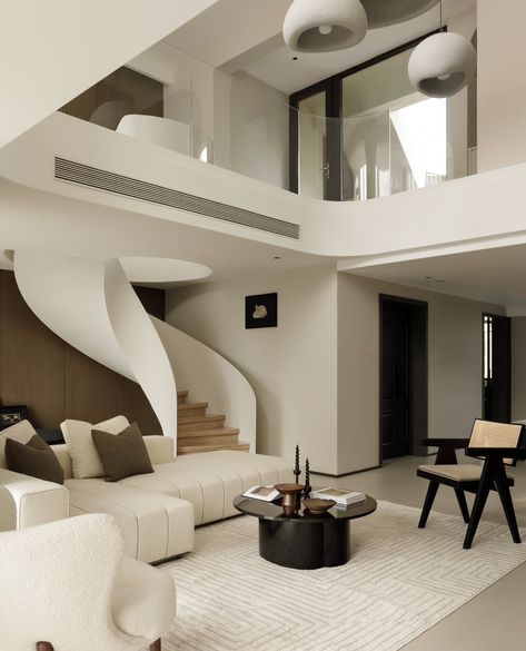 In interior design, curved lines can introduce a sense of softness, flow, and movement to a space. They also create contrast with the sharp angles of straight forms and geometric shapes. In this space, the white of the curved staircase is complemented by the soft lines, creating a seamless transition between levels and giving the space a softer appearance. The tall TV wall balances the overall rhythm of the space. The majority of the furniture features warm colours such as coffee and grey,... Modern Organic Interior Design, Organic Interior Design, Dwelling Place, Western Kitchen, Chinese Interior, Staircase Wall, Warm Colours, Unique Furniture Pieces, Warm Home