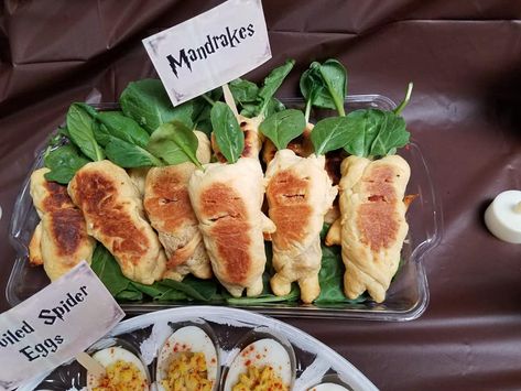 Mandrake Pigs in a Blanket. I cut hot dogs in half, and wrapped them in crescent rolls. After they baked, I cut holes for eyes and mouths. I also cut tiny holes on the top and put a spinach leaf in each hole. Nerdy Party Food, Harry Potter Birthday Dinner Ideas, Harry Potty Food Ideas, Harry Potter Food Inspiration, Goblet Of Fire Party Food, Movie Themed Dinner Ideas Harry Potter, Harry Potter Halloween Party Food, Harry Potter Food Theme, Harry Potter Meals Dinners