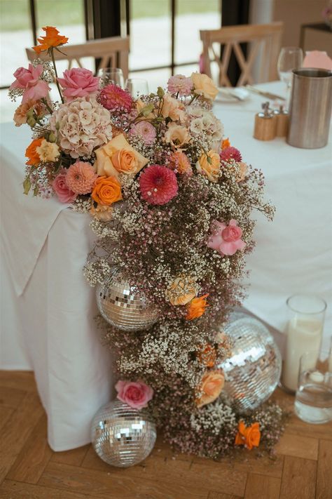 Pink and orange wedding flower decorations with gypsophila, roses, dahlias and more with disco balls Pink And Orange Wedding, Disco Ball Decorations, Retro Wedding Theme, Flower Cloud, Wedding Sunglasses, Orange Wedding Flowers, Disco Theme, Pear Tree, Ball Decorations