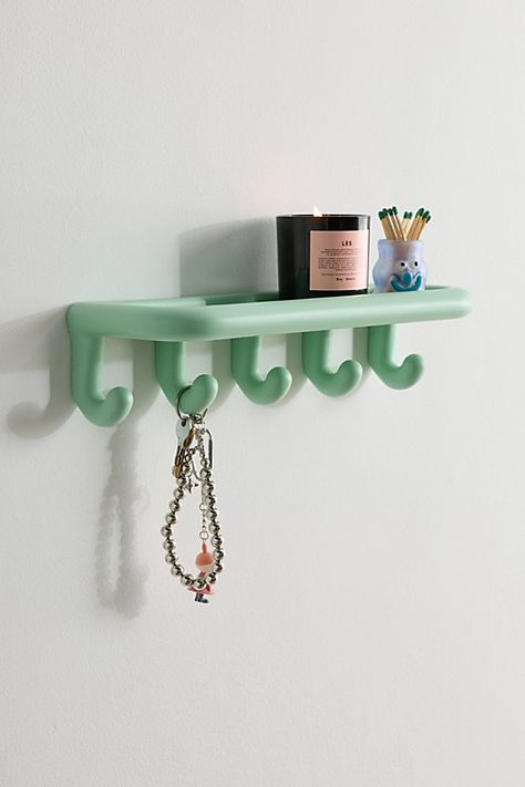 Create a kitschy wall display with this multi-tasking storage shelf. This resin wall storage shelf features bubbled, curving edges that lends a playful look to your entryway, bathroom and everywhere in between. Perfect for displaying trinkets, perfumes and crystals on top of the shelf, this wall storage solution features five jumbo hooks to hold your jackets, scarves and other accessories. Available exclusively at Urban Outfitters. Features Harper Colorful Wall Multi-Hook Shelf from UO Home Resin wall shelf Playful wall storage shelf with bulbed detailing Five hooks below to hold your coats, scarves and accessories Wall mount capable UO exclusive Content + Care Mounts to wall - instructions and hardware are included Resin Wipe clean Imported Size Dimensions: 16.1" l x 5.1" w x 3.9" h Weigh Wall Storage Shelf, Hook Shelf, Wall Storage Shelves, Home Basement, Uo Home, Accessories Wall, Entryway Bathroom, Wall Storage, Multi Tasking