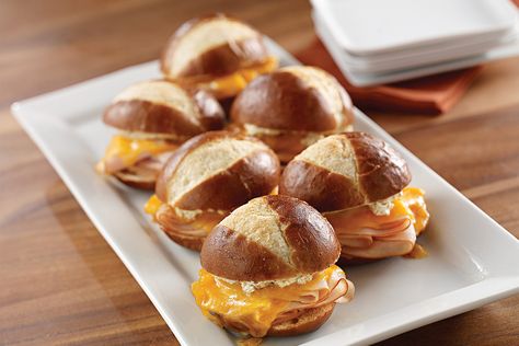 Serve these Turkey-Pretzel Sliders from My Food and Family on game day! Sandwiched on a pretzel roll and baked until the cheddar cheese melts, these turkey-pretzel sliders are simple to make and fun to share. Pretzel Sliders, Pretzel Sandwich, Sandwich Rolls, Turkey Sliders, Slider Sandwiches, Pretzel Bun, Hot Appetizers, Mini Sandwiches, Slider Recipes