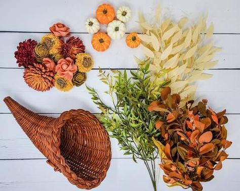 Outside of a golden brown turkey with all the trimmings, there are few things so iconic of Thanksgiving as a cornucopia. And what is better than a horn full of flowers and greenery?!Below, I’ll show you how to replicate a perfect cornucopia with sola wood flowers. This will make for a perfect colorful centerpiece for your Thanksgiving table.What You'll Need: Here is what I used for this project: Cornucopia (I found this one at Goodwill!) Sola wood flowers from Oh You're Lovely (spi… Cornucopia Centerpiece Decorating Ideas, Cornucopia Decorating Ideas, Thanksgiving Decorations Cornucopia, Cornucopia Centerpiece Diy, Thanksgiving Cornicopia Crafts, Cornucopia Diy, Fall Diy Centerpieces For Table, Cornucopia Decor, Cornucopia Wreath