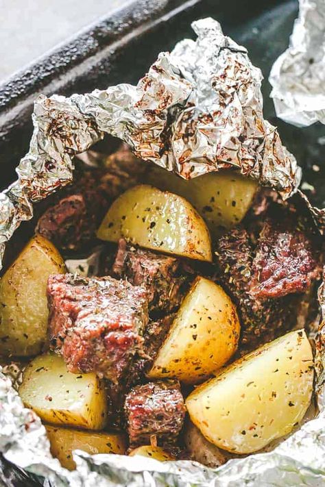 Delicious steak & potatoes recipe! Seasoned with garlic and herbs, then cooked inside foil packets this recipe is perfect for camping, grilling or the oven. #steak #potatoes #foilpacks #camping #grilling #cookout #outdoorcooking Garlic Herb Steak, Steak Foil Packets, Foil Packet Potatoes, Seared Salmon Recipes, Foil Pack Dinners, Foil Packet Dinners, Garlic Steak, Delicious Steak, Foil Pack Meals