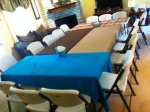 Tables set up for a group meal. Thanksgiving Table Settings For Large Group, Hosting Large Family Thanksgiving, Thanksgiving For A Large Group, Christmas Table Setting For Large Group, Christmas Table Settings For Large Group, Large Thanksgiving Dinner Table, Thanksgiving Garage Set Up, Table Layout For Party Small Space, Baked Potatoes Salad