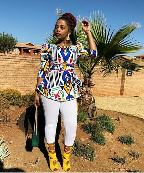 Clipkulture | Khanyi In Beautiful Ndebele Print Blouse With White Leggings and Yellow Strap Sandals Ndebele Print Outfits, Ndebele Print, Crazy Tops, Ndebele Traditional Attire, Kitenge Tops, Tops Ankara, Ankara Fashion Styles, Ankara Blouse, Ankara Styles For Women