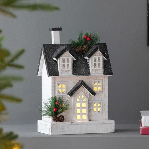 <p>Elevate your holiday decor with the charm of our <strong>Christmas Tabletop Wooden House</strong>. This classic village house is adorned with festive details like pine and red berries and is operated by batteries, allowing it to bring your console table or mantel display to life. Place this light-up house on a side table as a standalone piece, or incorporate it as part of a larger village scene for a truly magical display.</p>