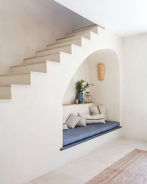 When planning the design for your space under the stairs, don’t be afraid to think outside the box. Your area doesn’t have to be all sharp lines and corners. A curved cut-out will make your space feel softer and welcoming. Follow the link for more under stairs ideas! Reading Nook Under Stairs, Mallorcan Villa, Mallorca House, Under Stairs Ideas, Stairway Storage, Villa Renovation, Space Under Stairs, تحت الدرج, Concrete Staircase