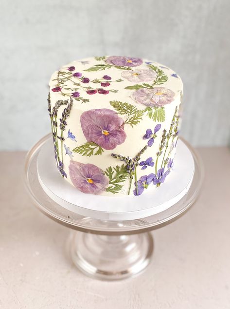 Serve up some natural elegance at your next gathering with our Single-Tier “Garden Party” Celebration Cake. Featuring an abundant, full-coverage arrangement of fresh and pressed botanicals against a canvas of white buttercream, this single-tier, four-layer cake is set-up on a display-ready foam-core drum, yielding more servings and a more elevated look than our classic Garden Party cake. Each cake utilizes seasonal, baker’s choice florals in your choice of three color palettes. Need more serving Garden Cake Ideas, Fall Cake Flavors, Garden Themed Cake, Baby In Bloom Cake, Garden Party Cake, Wedding Cake Forest, Two Tier Wedding Cake, Tier Garden, Garden Party Cakes